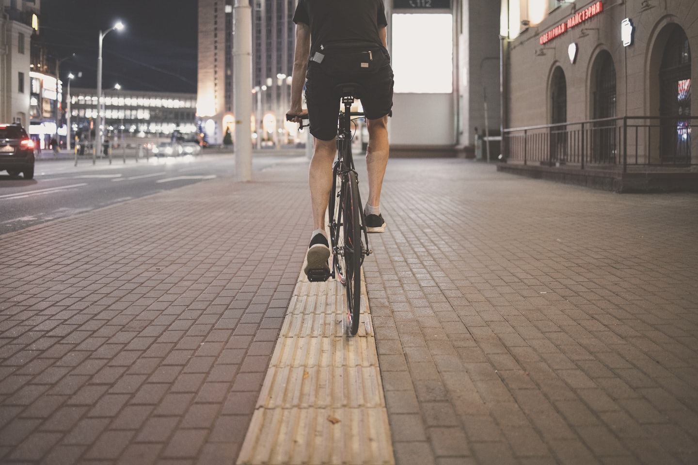 An image of a cyclists legs on a city street at night