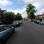 Healmet cam viewpoint of a Quiet street with parked cars