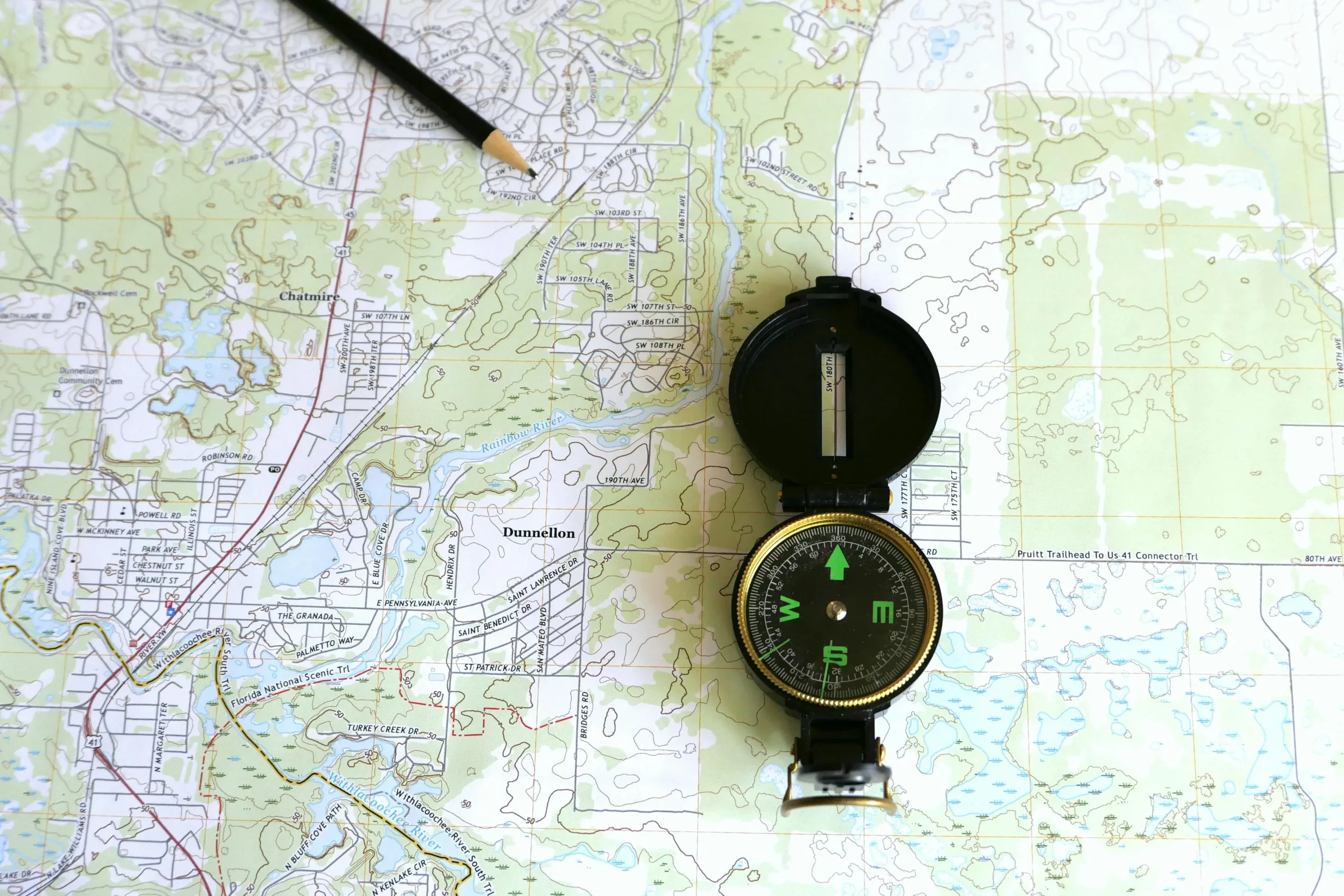 A compass lay on top of a topographical map
