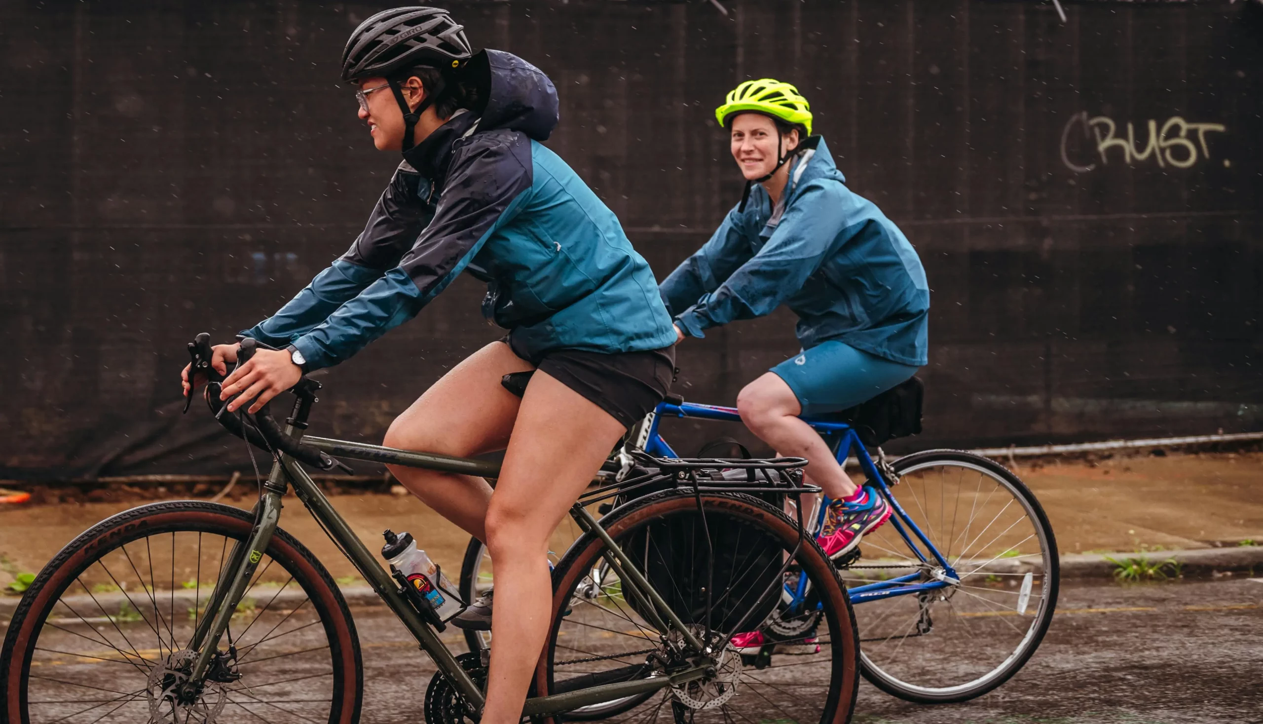 Two cyclists on a road on a rainy day