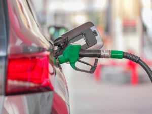 A fuel pump inside a red car filling the tank