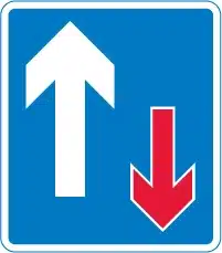 Priority over oncoming vehicles sign blue with a red and white arrow